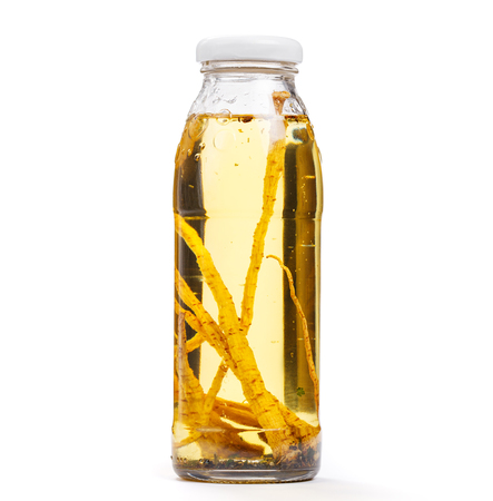 Exotic sunflower oil bottle with parsley root and spices. Object on white backgroundの写真素材