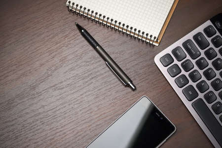 Business workspace desktop background with pen, phone, notebook and keyboard. Empty space, top viewの写真素材
