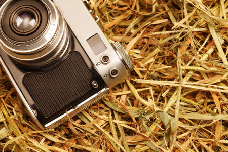 Film old retro camera on hay rural backgroundの写真素材