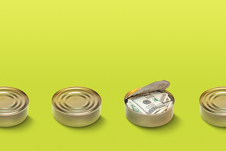 Line of tin cans with open one with money inside. Stand out from the crowd , earning money concept