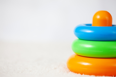 Pyramide toy (preschool logic game) background on bright white textile. Low aperture shotの写真素材