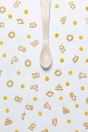 Different shapes pasta mix with spoon. Baby food, flat lay, creative conceptの写真素材