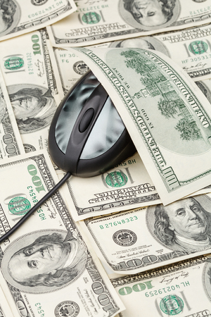 Computer mouse on dollar banknotes. Online earnings, IT, making money with computer conceptの写真素材