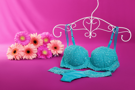 Panties, bra on a hanger and gerberas in the backgroundの写真素材