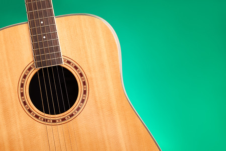 Part of acoustic guitar on green background with copy spaceの写真素材