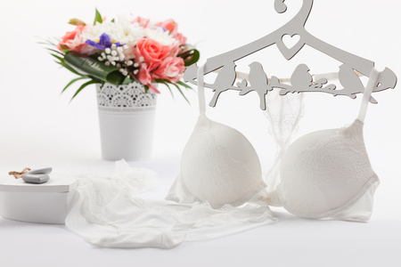 White bra and panties. Flowers in vase, casket, hanger decorated with bird shapesの写真素材