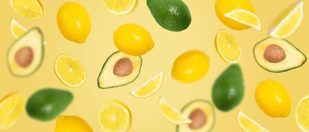 Avocado and lemon (whole, half and slice) ingredients mix. Flying creative fruits on wide backgroundの写真素材