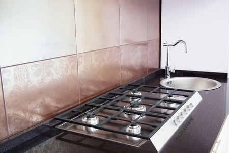 Kitchen - cooking area with gas stove and tile wallの写真素材