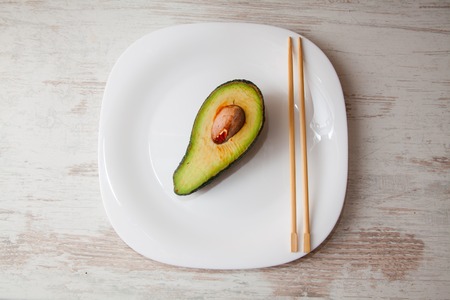 various Japanese sushi on white plate with chopsticks on wooden background