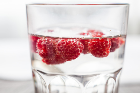 Sparkling raspberry lemonade water in a transparent glassの写真素材