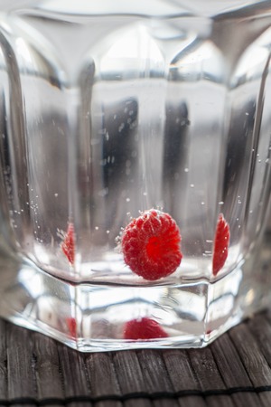 Sparkling raspberry lemonade water in a transparent glassの写真素材