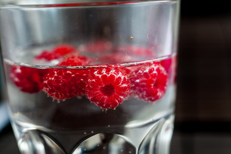 Sparkling raspberry lemonade water in a transparent glassの写真素材