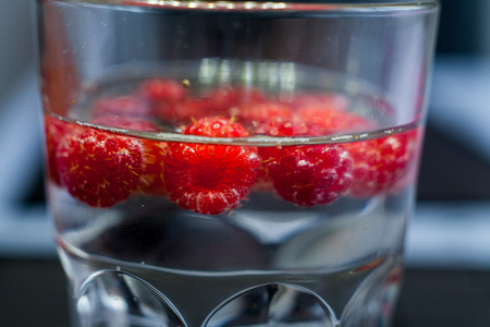 Sparkling raspberry lemonade water in a transparent glassの写真素材