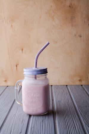 Chocolate coffee milkshake with ice cream scoop served in glass mason jar with retro cocktail tubes on gray texture background. Summer sweet drinkの写真素材