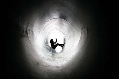Silhouette of a girl in a big pipeの写真素材
