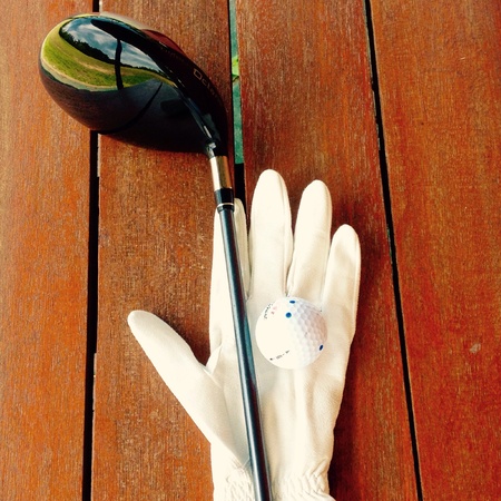 Golf clubs and golf balls on the wooden floor.の素材