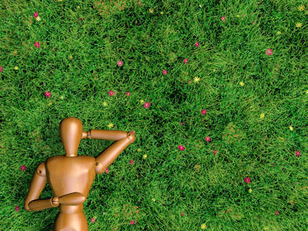 Wooden man is sleeping on grass lawn