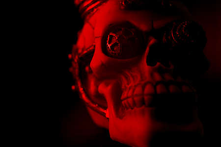 A scary little skull with red lights in the dark