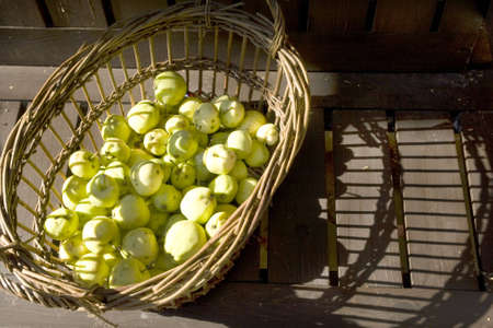 Apples in a basket with wood textureの写真素材