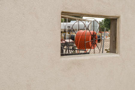 Industrial site as seen through window in wall