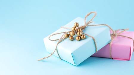 Two gift boxes of pink and blue on a blue background, minimalism photography. Place for text.
