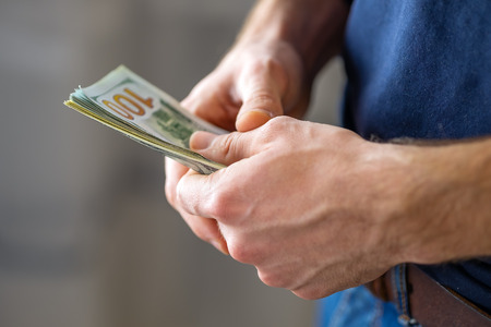 Male hands with banknotes close up. One hundred dollar bills.