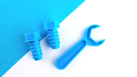 Two toy plastic bolts and wrench of blue color on a white-blue background. Place for text.の写真素材
