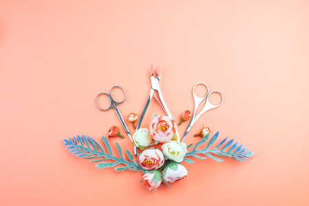Manicure tools on a pink background decorated with flowers. Beauty concept.の写真素材