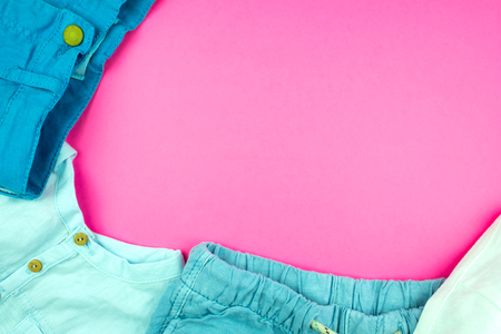 Summer clothes, shorts, pants and t-shirts on a pink background.  Place for design.の写真素材