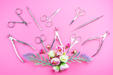 Manicure tools on a pink background decorated with flowers. Beauty concept. Place for text.の写真素材