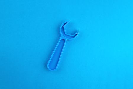 Toy plastic wrench of blue color on a blue background. Place for text.の写真素材