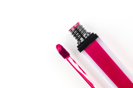 Open lipstick with a brush for applying and smear in red on a white background.の写真素材