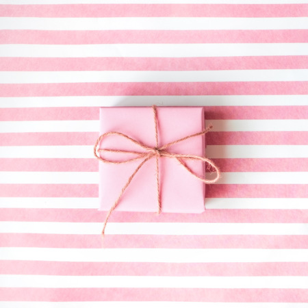 Pink gift box with a pink ribbon on a pink background .  Holiday concept. Copy space.の写真素材