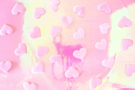 Beautiful silk pink hearts on a holographic pink background. Holiday concept Valentine Day. Plase for text . Flat lay.の写真素材