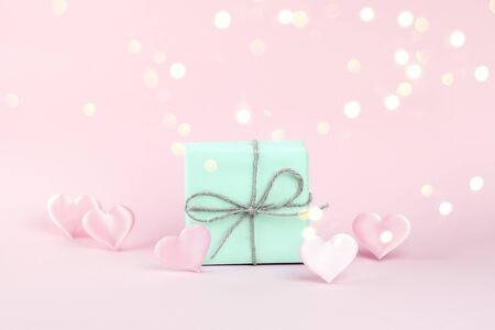 Gift of blue color decorated with a string of twine on a pink background .の写真素材
