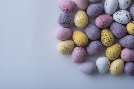 Colorful speckled mini Easter eggs on a plain back ground shot from above with copy space flat lay