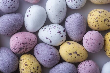 Colorful speckled mini Easter eggs on a plain back ground shot from above flat lay