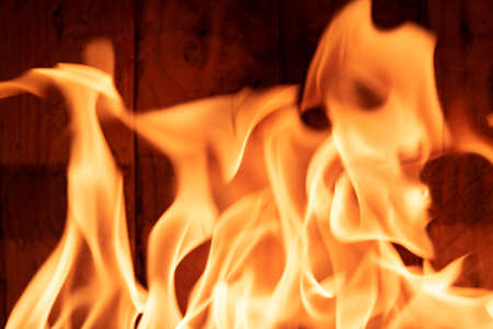 Bright orange and red flames against rustic wooden backgroundの写真素材