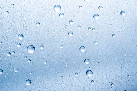 water drops on glass back ground abstract blue color tonesの写真素材