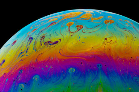 Close up macro shot of multicolored soap bubbles with a black background