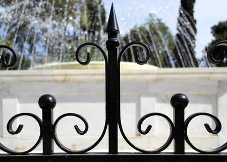 black railings in front of the fountainの写真素材
