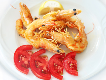 fried shrimps with fresh tomatoes at a greek tavern - delicious mediterranean seafoodの写真素材
