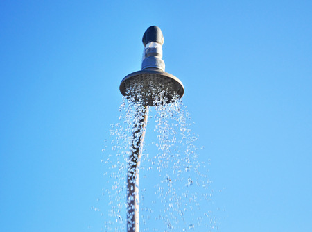 outdoors shower with running water near the swimming pool of the hotelの写真素材