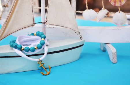 summer jewelry - agate gemstone bracelet - gold anchor bracelet - turquoise backgroundの写真素材