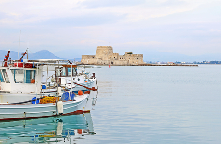 Bourtzi castle behind the traditional fishing boats at Nafplio town Argolis Greece