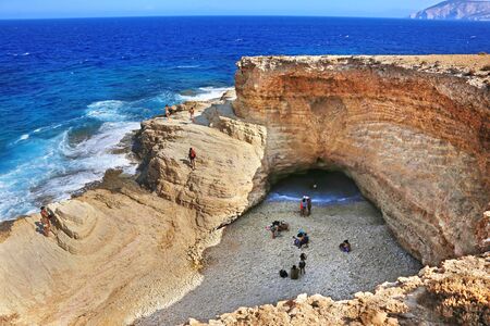 ANO KOUFONISI GREECE, AUGUST 27 2019: the famous Gala beach at Ano Koufonisi island Greece - the sea enters the beach via a narrow corridor of the open cave of the rocks - Gala means milk in the greek language. Editorial use.のeditorial素材