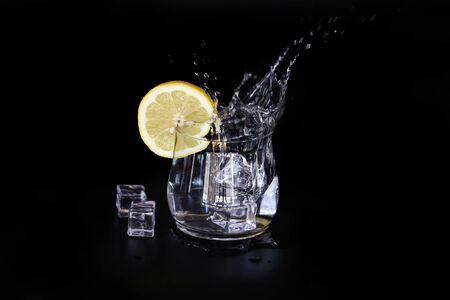 ice water splash with lemon slice isolated on black backgroundの写真素材