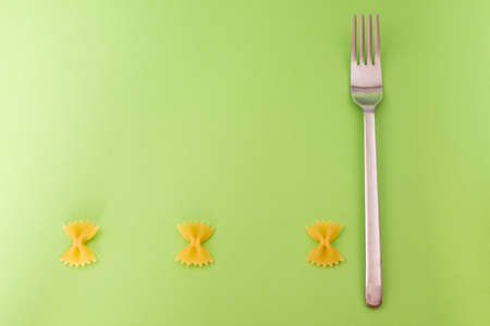 Creative background for advertising, raw bow tie-shaped paste is aligned at the bottom with a steel...