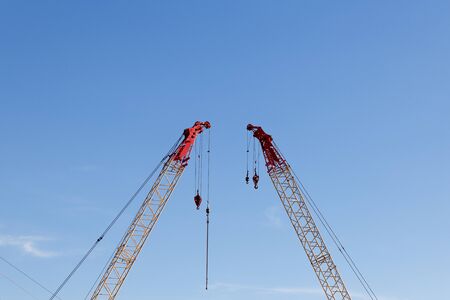 modern construction cranes in front of blue skyの写真素材