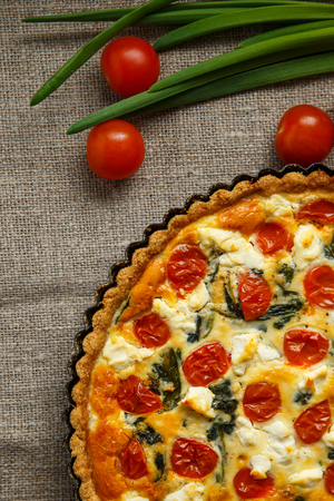 Vegetarian homemade pie, Quiche with tomatoes, spinach and feta cheese.の写真素材